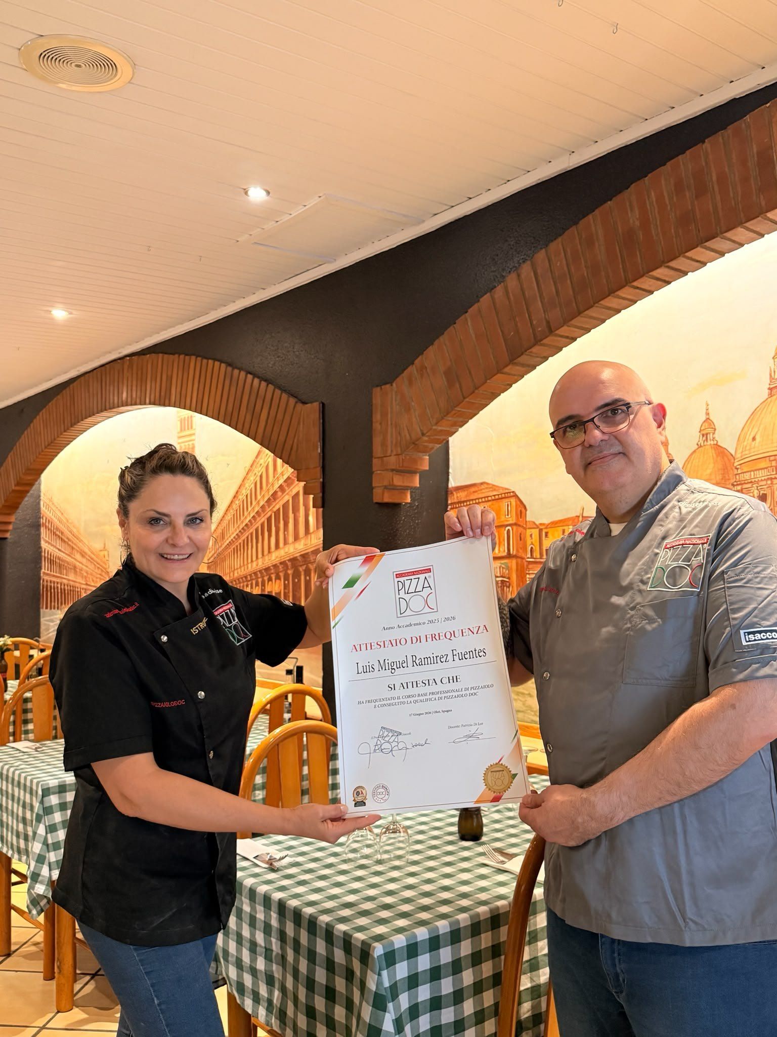En Luiggi i Patrizia Di Leo amb un diploma a la sala de la trattoria